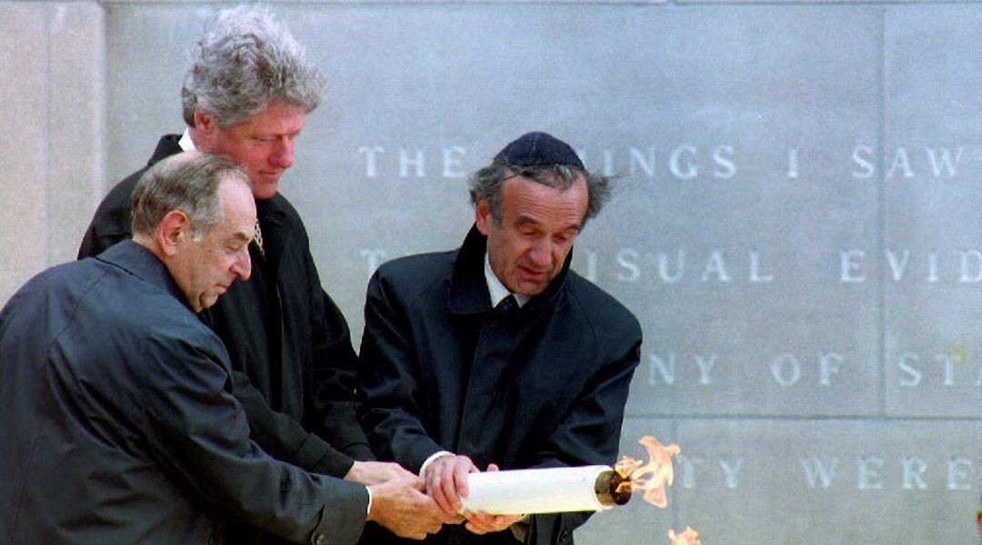 U.S. President Bill Clinton, center, lights the eternal flame at the dedication of the United States Holocaust Memorial Museum with help from Memorial Council chairman Harvey Meyerhoff, left, and founding chairman Elie Wiesel, April 22, 1993. (Renaud Giroux/AFP via Getty Images)