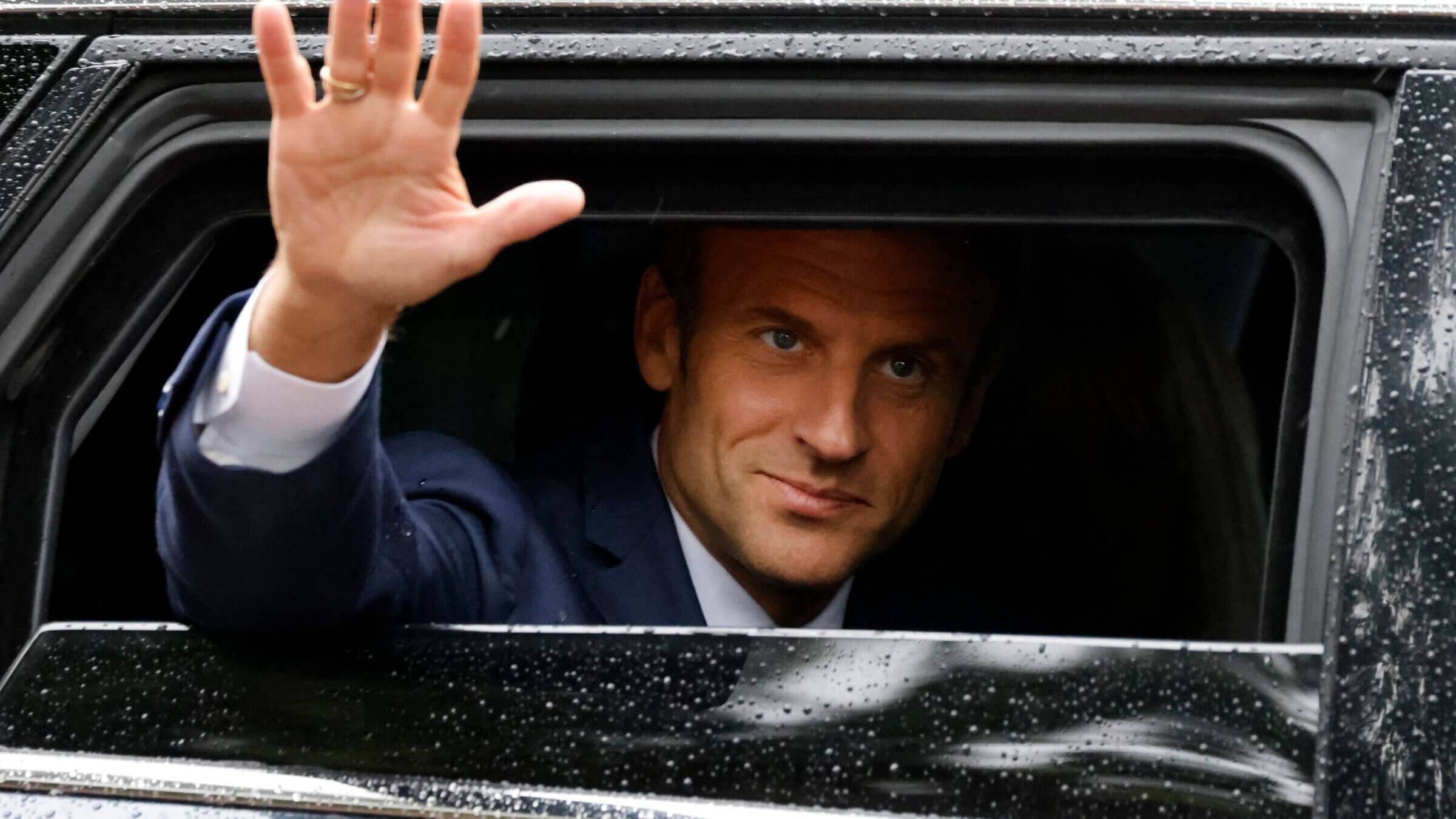 France’s President Emmanuel Macron waves as he leaves after casting his vote in the second stage of French parliamentary elections on June 19, 2022.