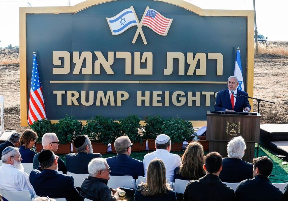 Israeli Prime Minister Benjamin Netanyahu gives a speech before the newly-unveiled sign for the new settlement of "Ramat Trump", or "Trump Heights" in English, named after the incumbent US President during an official ceremony in the Golan Heights on June 16, 2019.